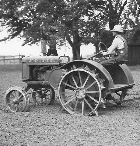Historischer John Deere „GP“ Allzwecktraktor, der eine John Deere No. 7 Bodenfräse auf dem Feld zieht