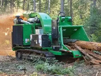Der Bandit Industries Laufketten-Baumhäcksler 2290, angetrieben von einem John Deere JD14-Industriemotor, häckselt Baumstämme.